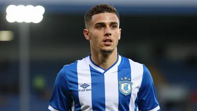 A 30-year-old, 5'10'' tall, FC Halifax Town midfielder, wearing a blue and white striped shirt, made of a smooth...
