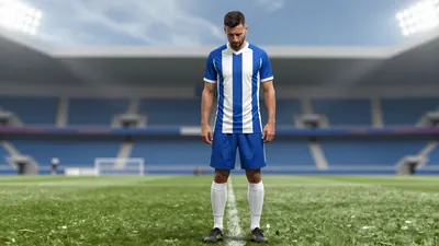 A 38-year-old defender in a floodlit stadium, wearing a blue and white striped shirt with a white collar, and white...