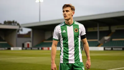 A tight action crop of a young FC Halifax Town player in a green and white kit, with a determined expression, as they...