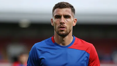 Mid-30s male midfielder, athletic build, intense expression, head-and-shoulders framed, wearing a plain FC Halifax Town...
