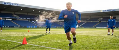 Will Harris, mid-30s, athletic build, sprinting with a blurred Hartlepool United-style amber shirt and black shorts...