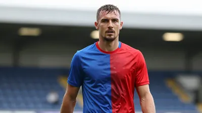 Mid-30s, muscular forward of FC Halifax Town, head-and-shoulders, drenched in sweat, eyes focused forward, wearing a...